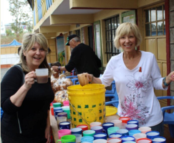 Paula Vail serving refreshments with a friend at a school in Africa