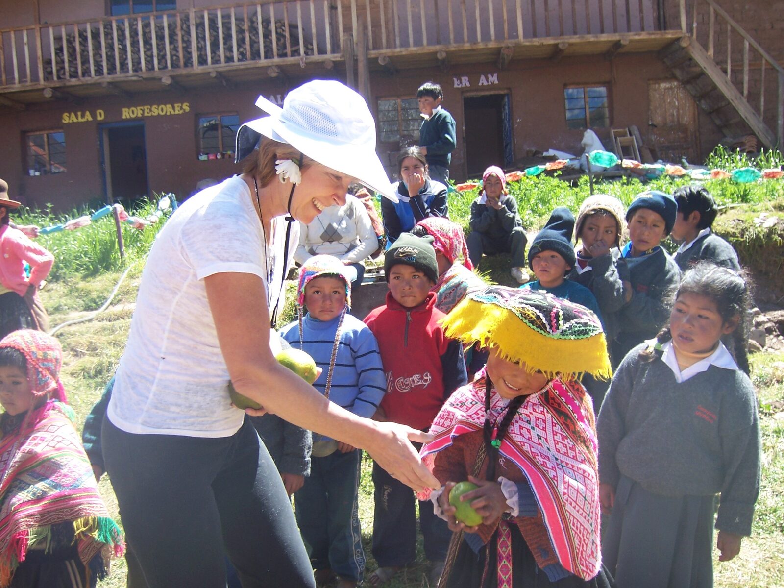 Paula Vail sharing fruit with schoolchildren in a village in the Sacred Valley, Peru